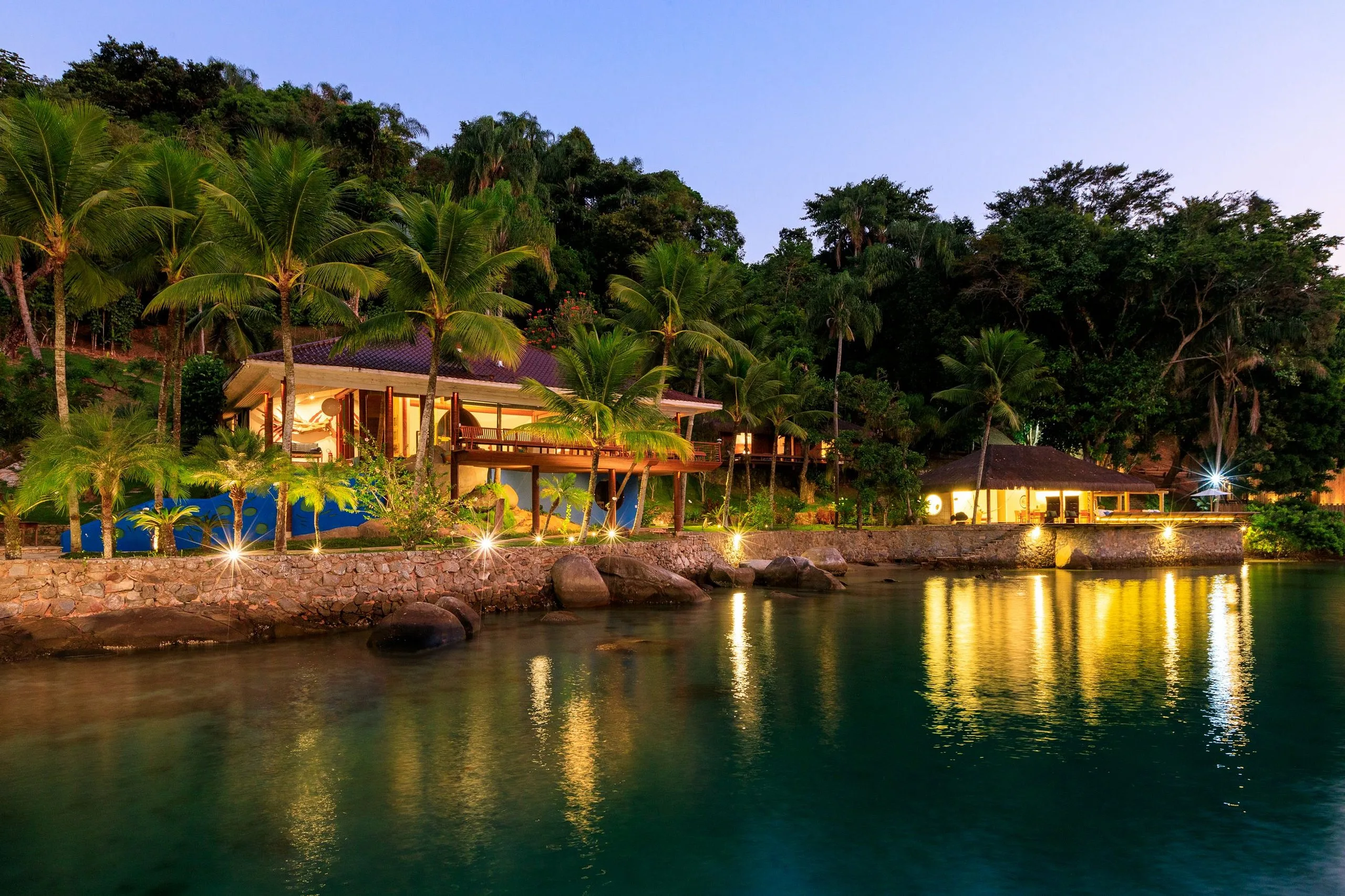 Houses lit by the water at dusk